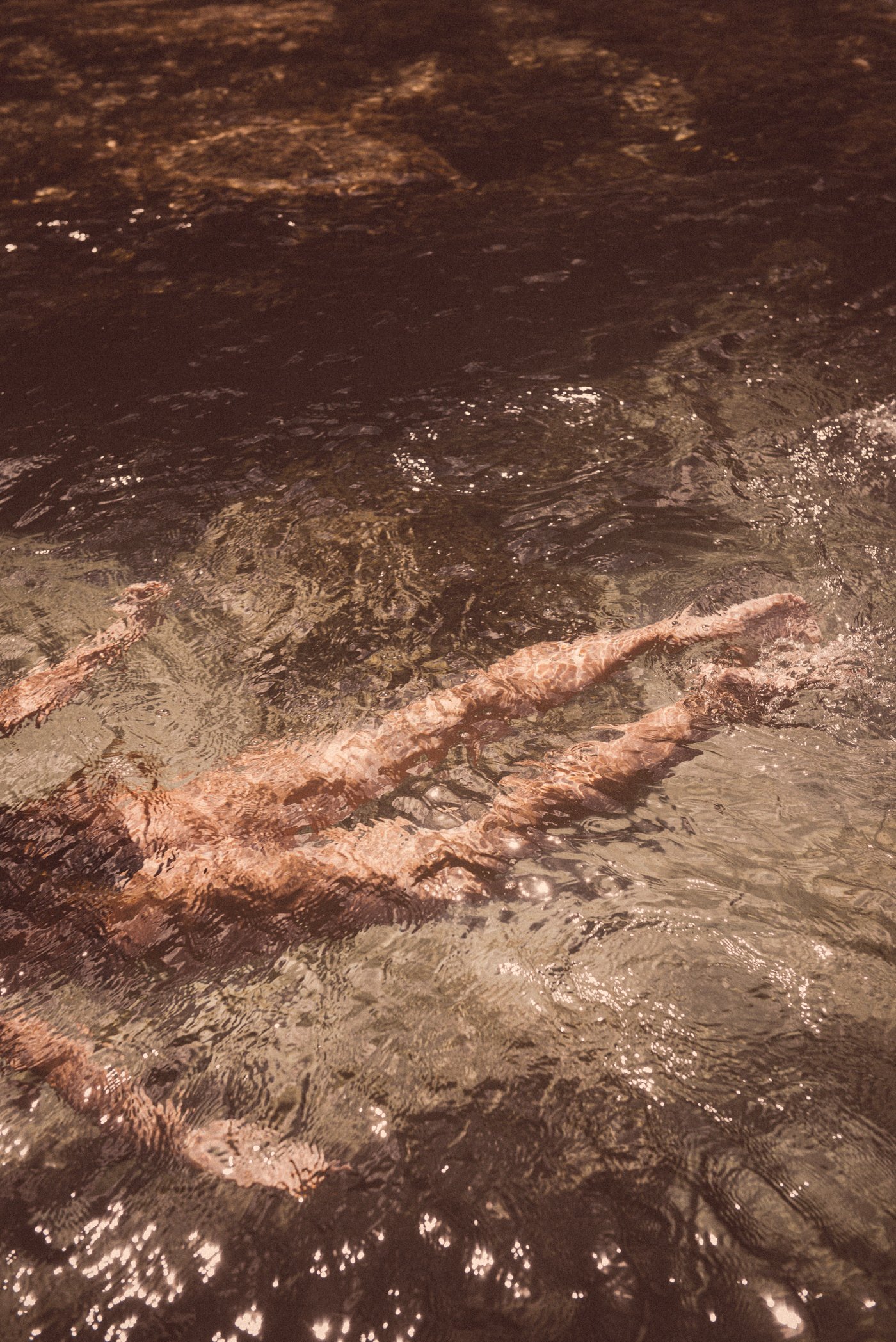 A swimmer gliding under sunlit water